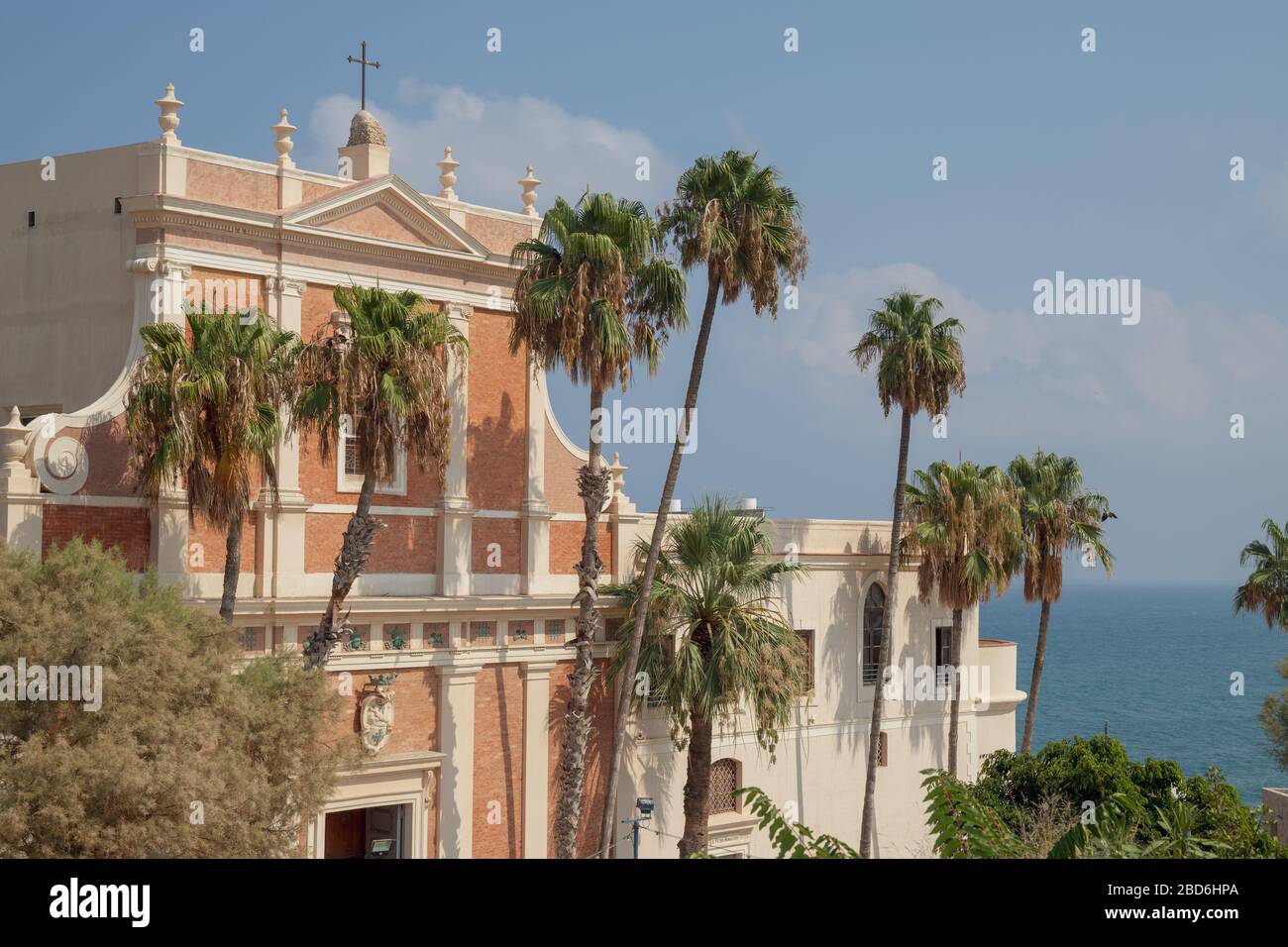 Palme di fronte alla Chiesa di San Pietro nella vecchia Giaffa, Israele con il Mar Mediterraneo sullo sfondo Foto Stock