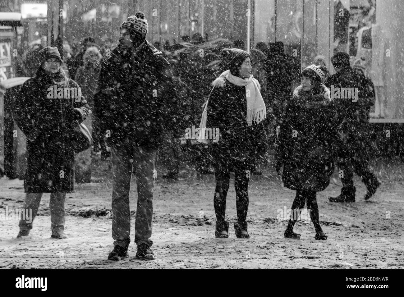 I newyorkesi stanno in piedi al semaforo rosso in Time Square durante la pesante nevicata. Manhattan, New York City, Stati Uniti d'America. Foto Stock