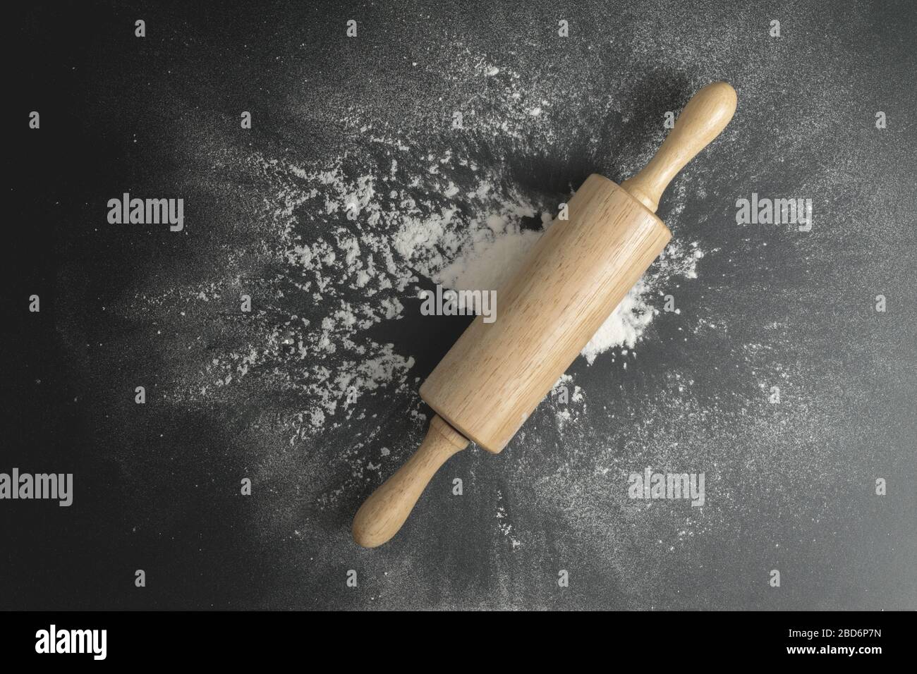 Rullo di pasta di legno sul tavolo nero con farina spalmata. Forno concetto fatto in casa. Foto Stock