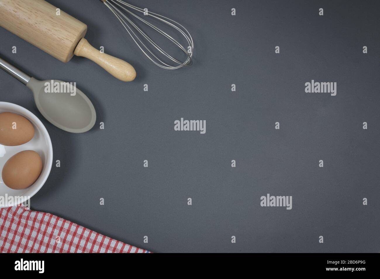 Rullo di pasta in legno e frusta sul tavolo nero. Forno concetto fatto in casa. Foto Stock