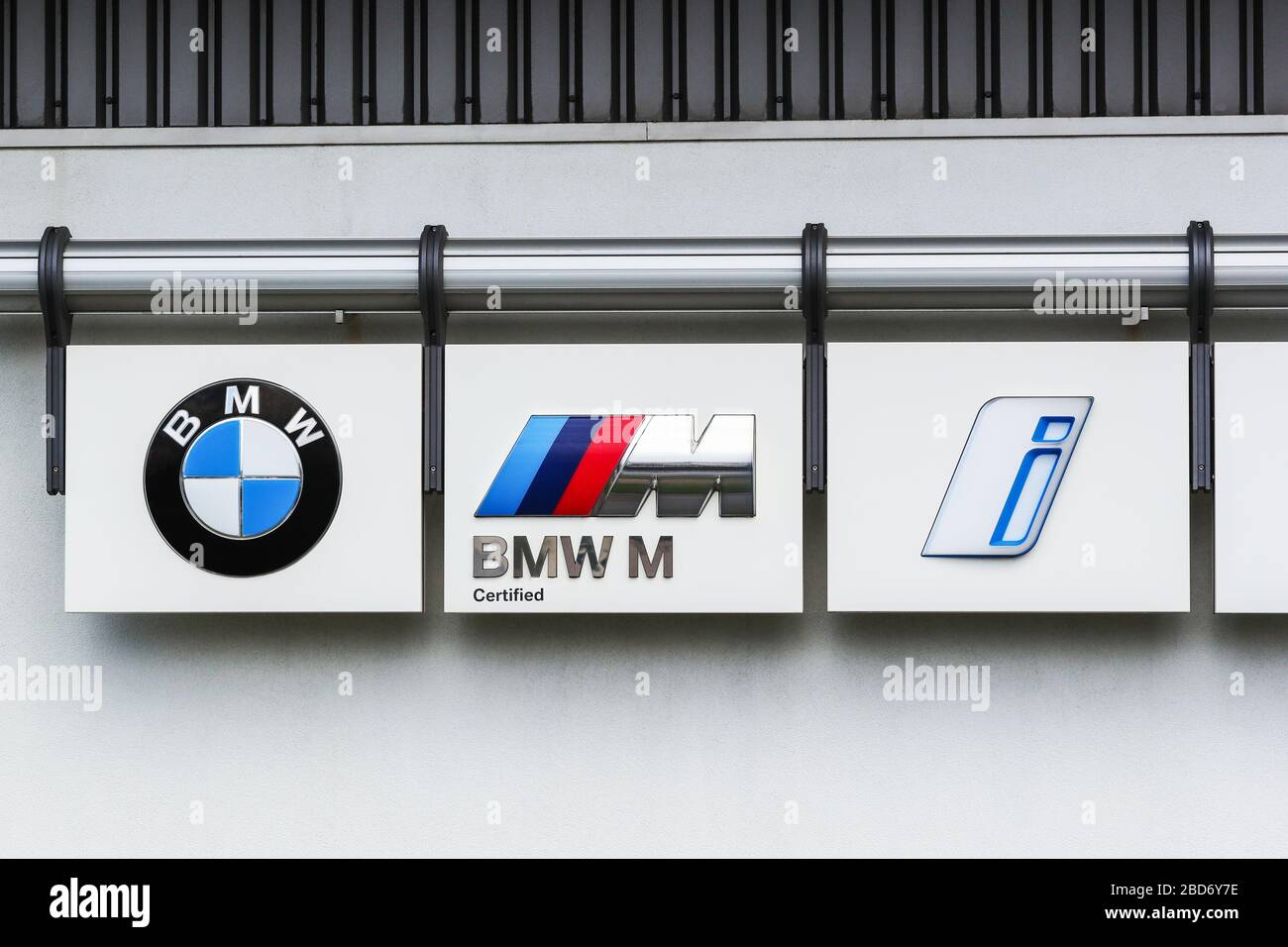 Logo BMW con il logo aziendale standard, il logo M sport e il nuovo logo "i" dei veicoli elettrici, montati all'esterno di una concessionaria BMW, Ayrshire, Regno Unito Foto Stock