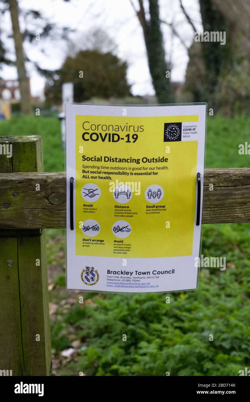 Covid 19 Avviso di salute pubblica su una recinzione adiacente ad un parco cittadino. Foto Stock