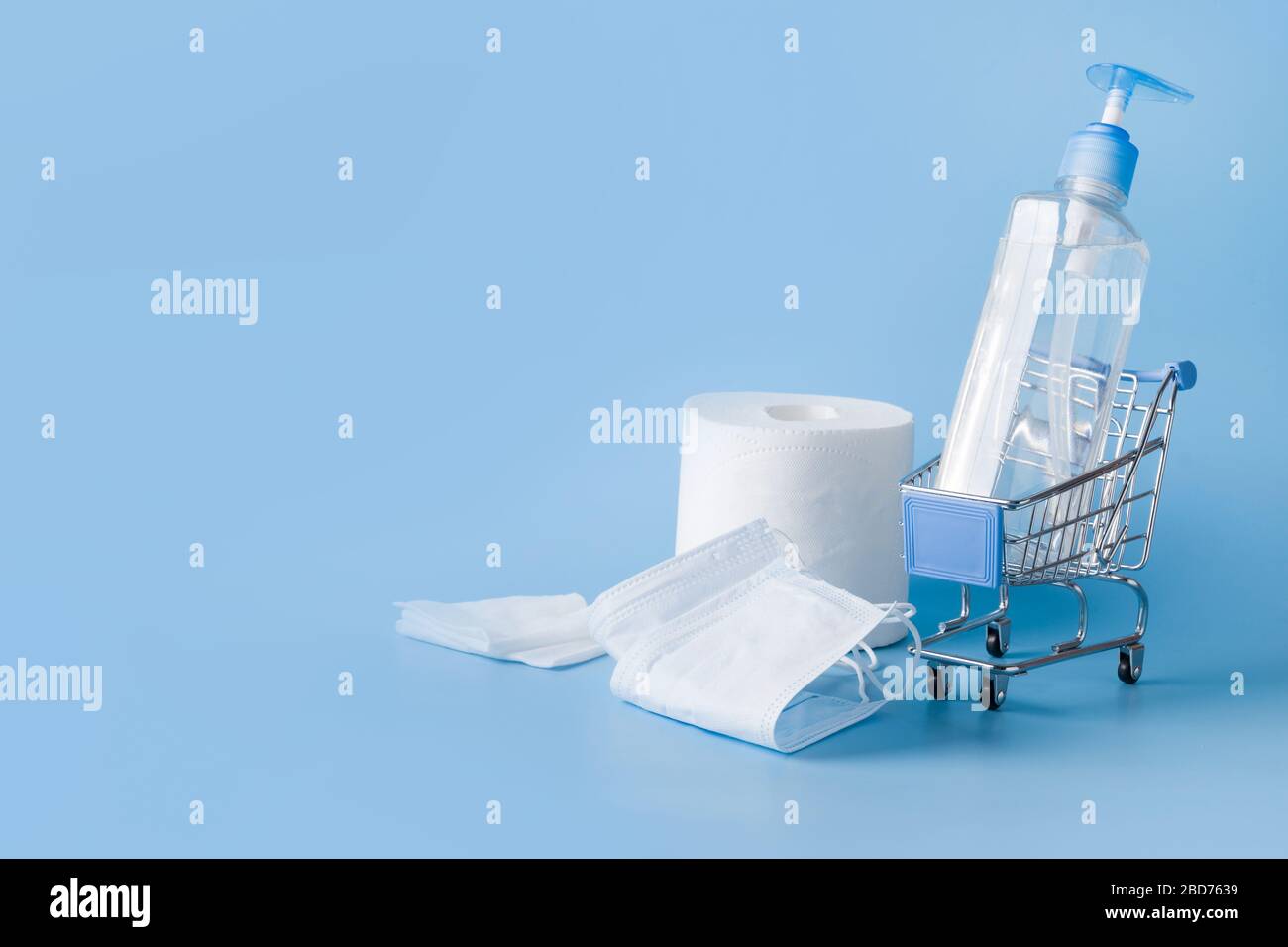 Carrello per alimentari con gel disinfettante, salviette bagnate, maschera protettiva. Concetto di pericoli dello shopping durante la pandemia di Coronavirus COVID-19. Scarso goo Foto Stock