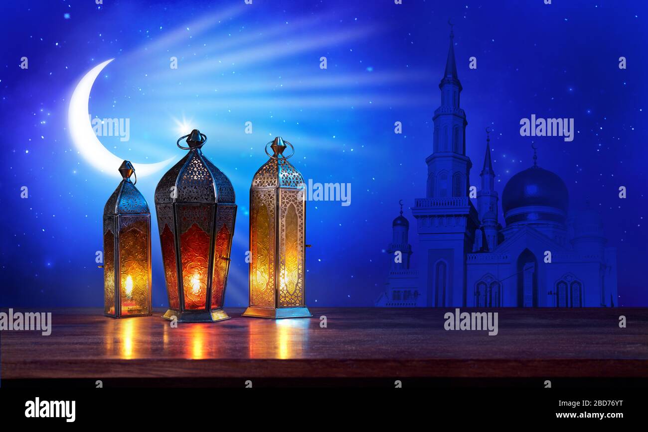 Lanterne Ramadan sul tavolo con luna e moschea su sfondo blu scuro. Bel biglietto d'auguri con spazio per fotocopie per le festività musulmane. Un Foto Stock