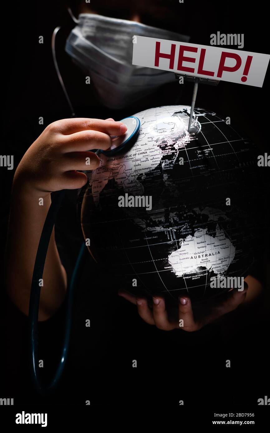 Kid Hold Globe mettere stetoscopio sulla sfera dove mostrato billboard aiutare le lettere rosse faccia coperta in maschera su sfondo nero. Epidemia pandemica Covid 19, Foto Stock