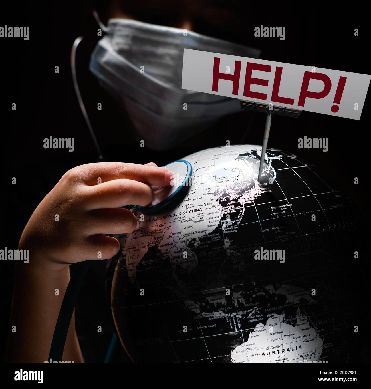 Kid Hold Globe mettere stetoscopio sulla sfera dove mostrato billboard aiutare le lettere rosse faccia coperta in maschera su sfondo nero. Epidemia pandemica Covid 19, Foto Stock