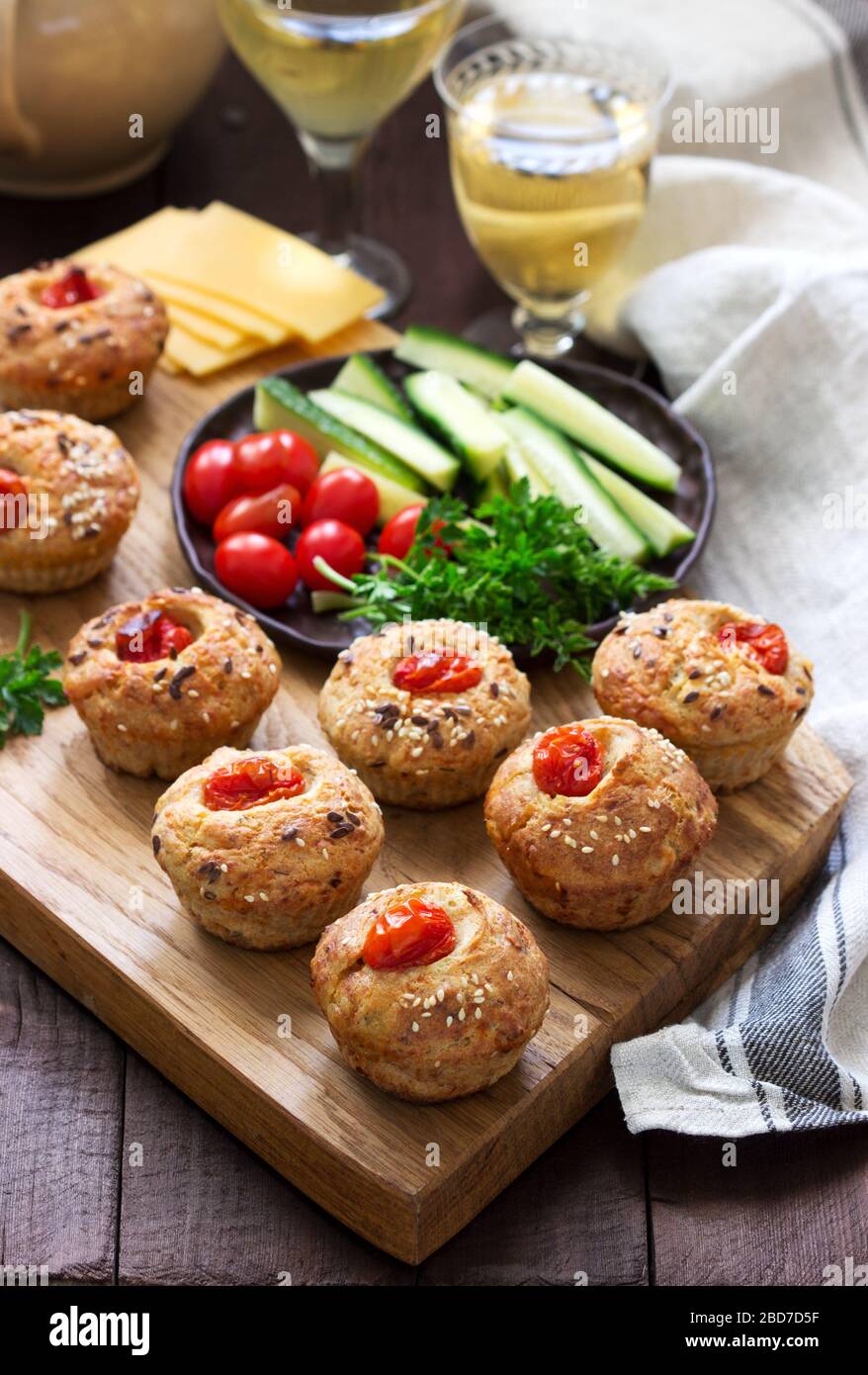 Muffin con formaggio, formaggio casolare e pomodori, verdure e formaggi serviti con vino. Foto Stock