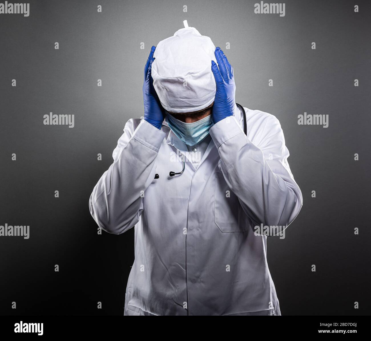 Medico stanco lavorato in uniforme bianca e maschera medica. Foto Stock