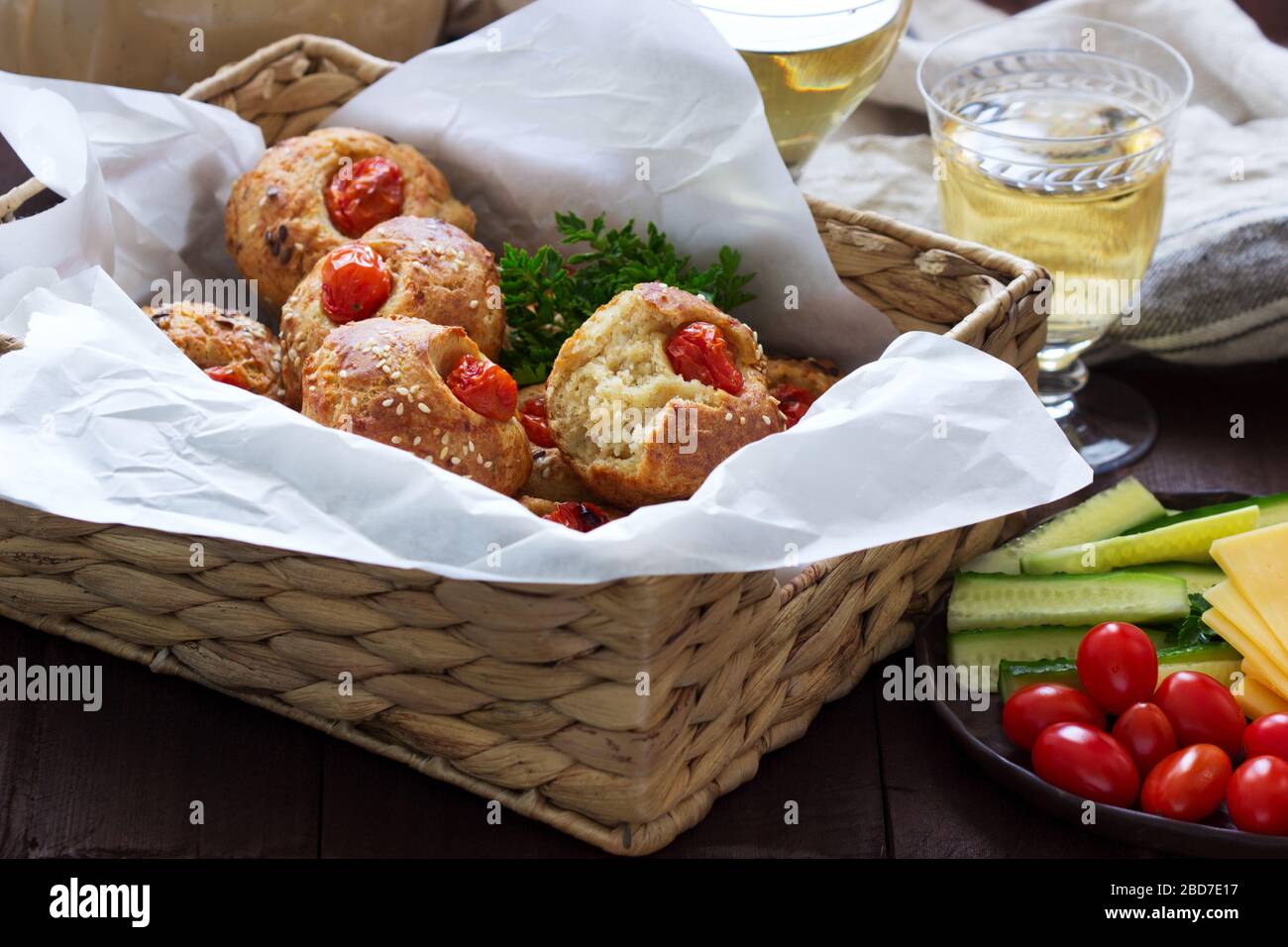 Muffin con formaggio, formaggio casolare e pomodori, verdure e formaggi serviti con vino. Foto Stock