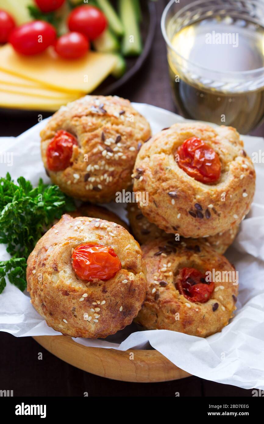 Muffin con formaggio, formaggio casolare e pomodori, verdure e formaggi serviti con vino. Foto Stock