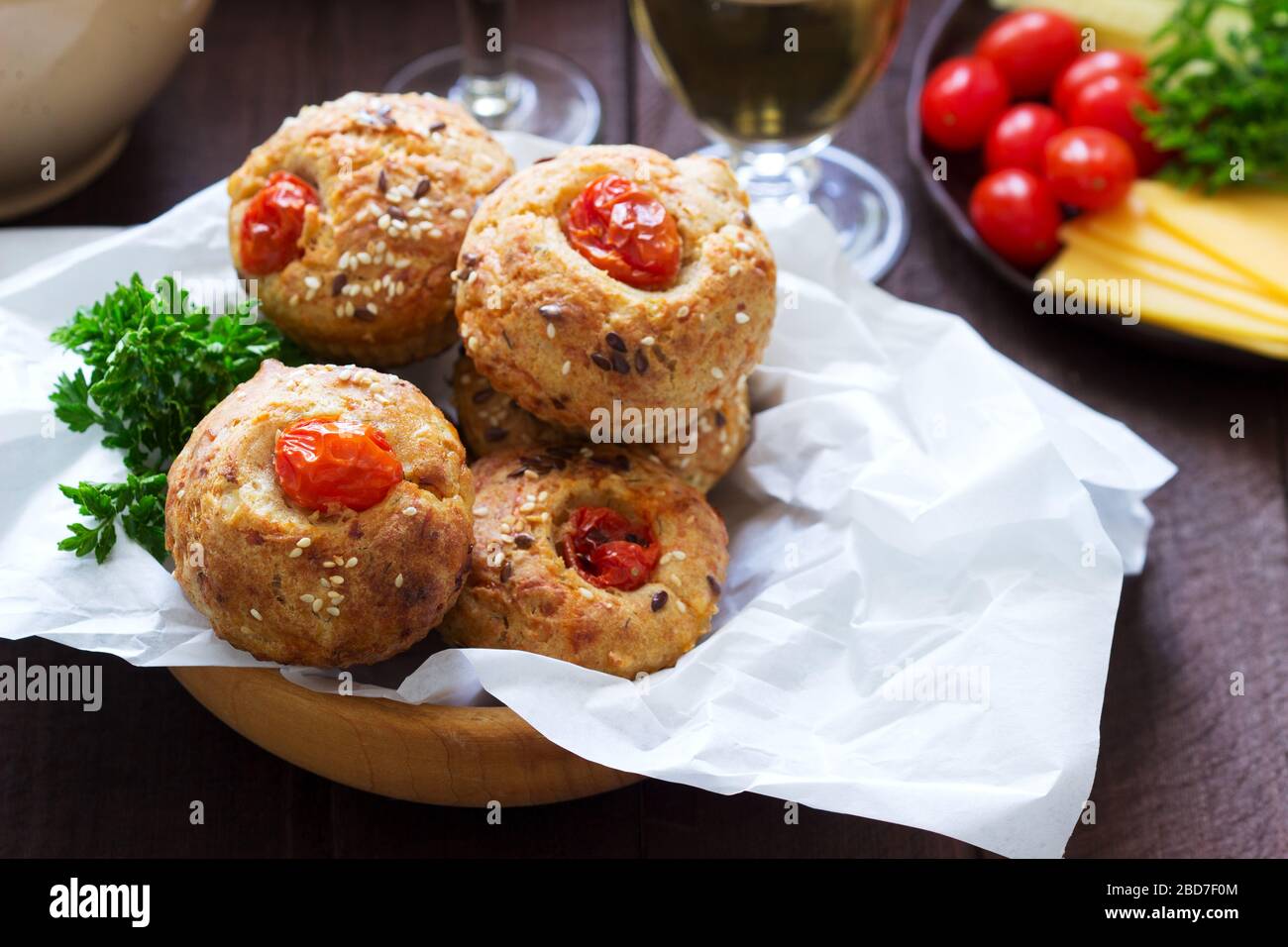 Muffin con formaggio, formaggio casolare e pomodori, verdure e formaggi serviti con vino. Foto Stock