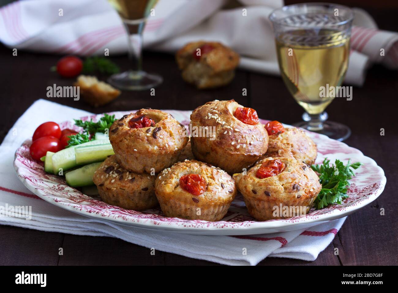 Muffin con formaggio, formaggio casolare e pomodori, verdure e formaggi serviti con vino. Foto Stock