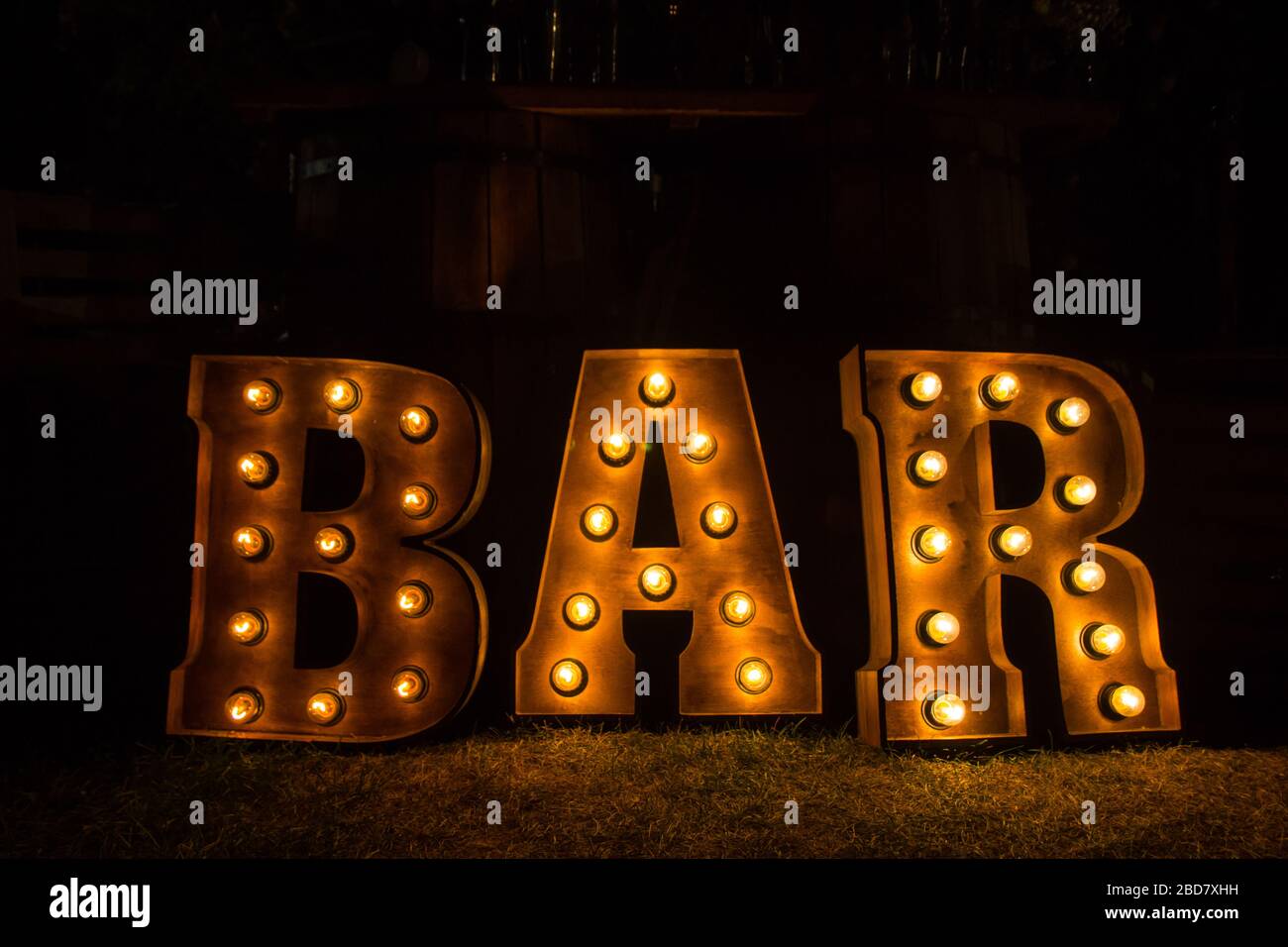 Grandi lettere luminose vicino al bar. Lampade gialle. Foto Stock