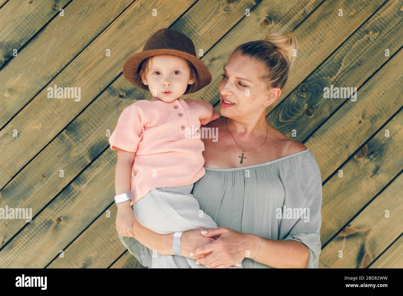 Emozione ritratto nonna e sua nipote in stile rurale clostere muslin su sfondo verde legno. Concezione familiare. Foto Stock