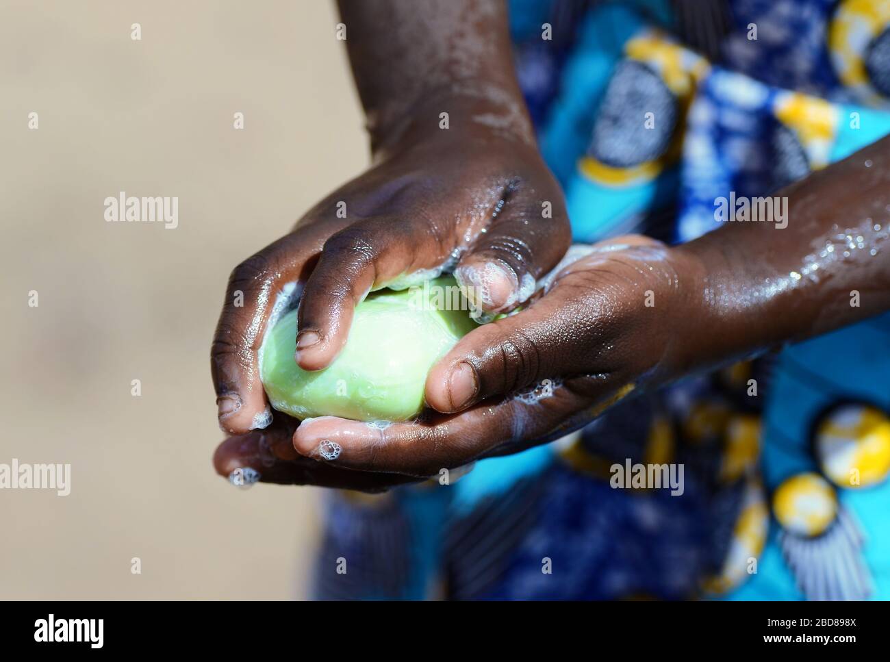 Simbolo di salute quando la ragazza africana lava le sue mani fortemente con sapone e igienizzante per evitare di contattare Virus Foto Stock