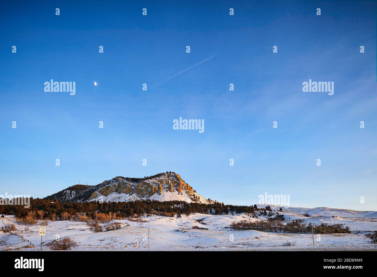 Un piccolo ranch sotto le scogliere coperte di neve in Montana, Stati Uniti Foto Stock