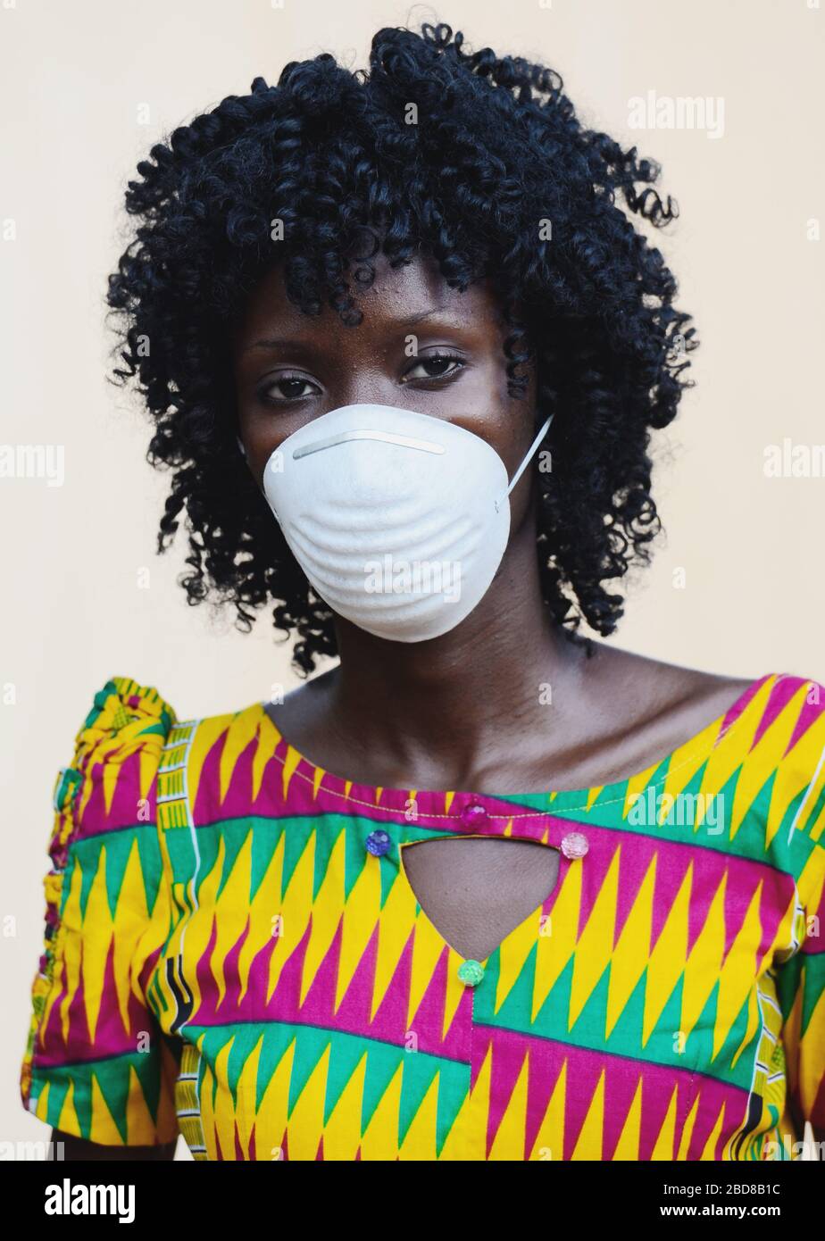 Maschere facciali per i popoli africani di fronte a epidemia globale, splendida donna africana indossando protezione facciale Foto Stock