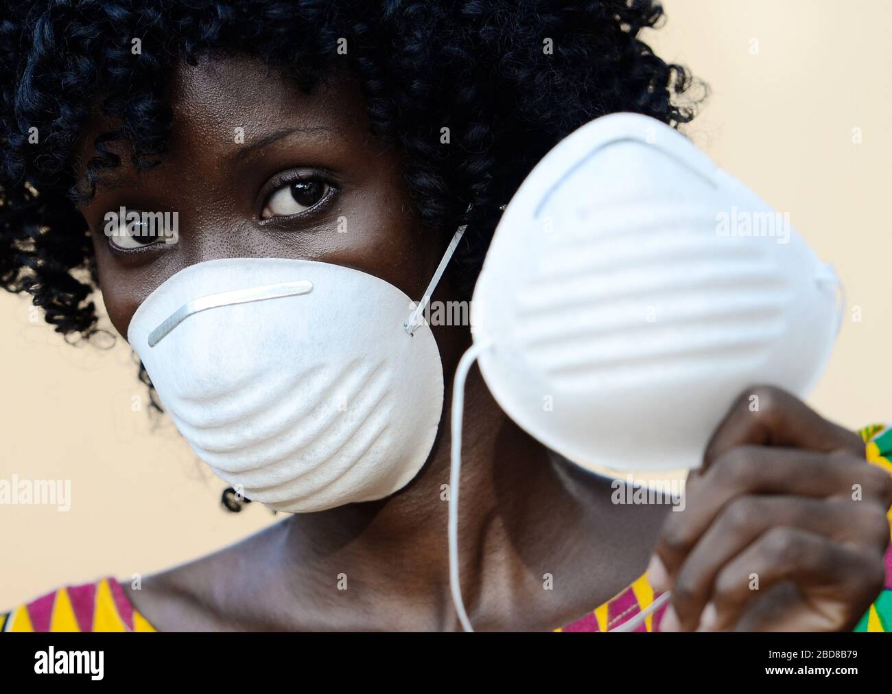 Giovane Africano Nero Donna indossare Medica prevenzione maschera viso indossare abbigliamento tradizionale Foto Stock