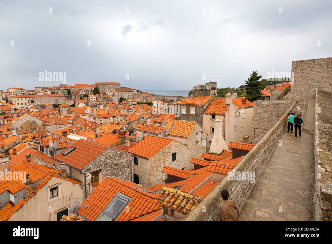 Turisti che camminano lungo la famosa parete della Città Vecchia, Dubrovnik, Croazia in una mattinata nuvolosa. Foto Stock