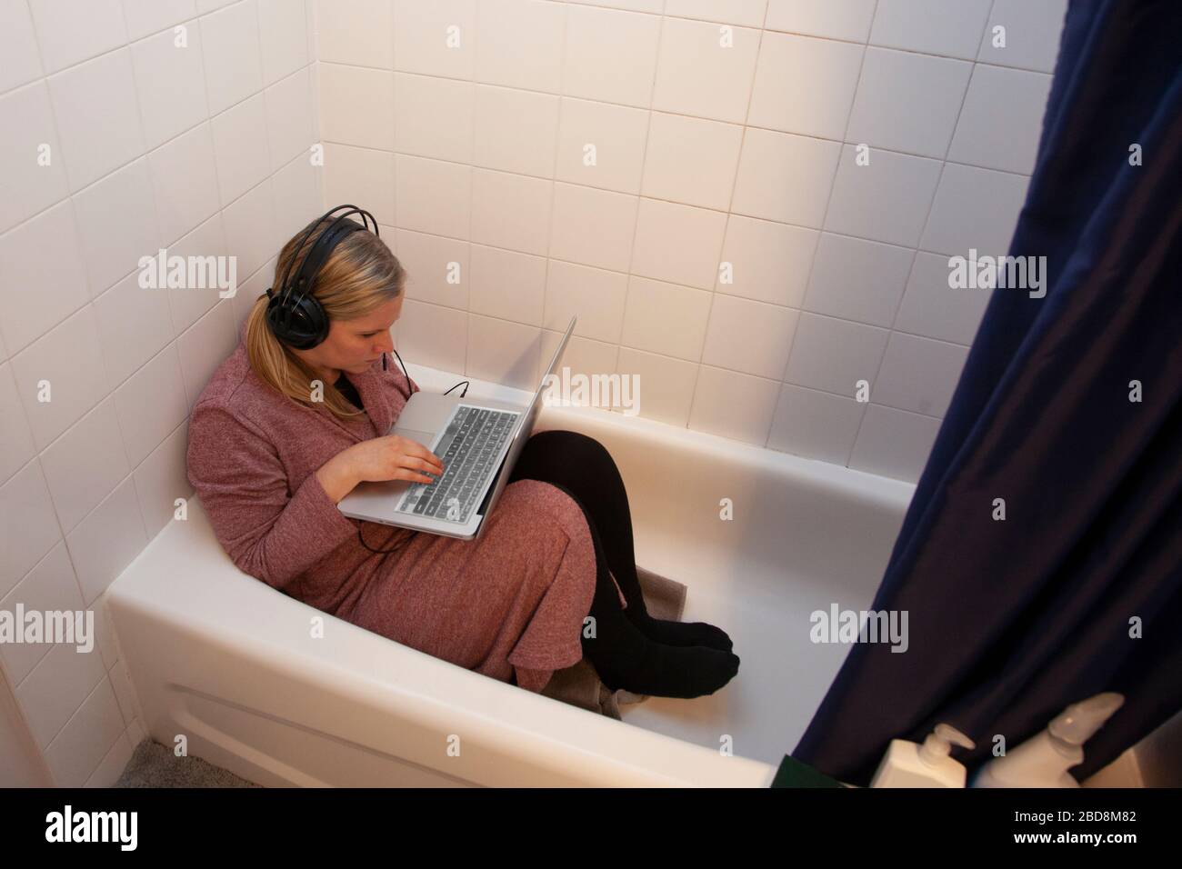 la persona ottiene il lavoro creativo dalla sede nel bathrub Foto Stock