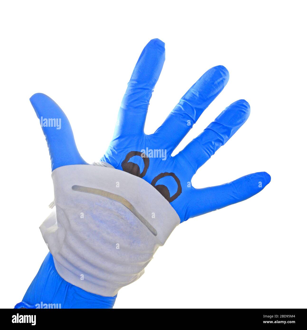 Mano con guanto chirurgico Blue con una maschera facciale raffigurante un viso con riferimento alla protezione medica contro il virus corona , covid 19. Foto Stock