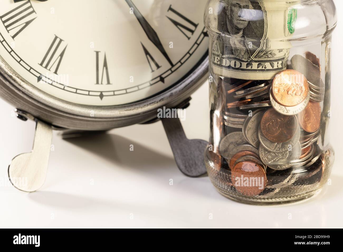 Denaro americano seduto vicino al desktop orologio. Il tempo è denaro o concetto di pianificazione finanziaria. Foto Stock