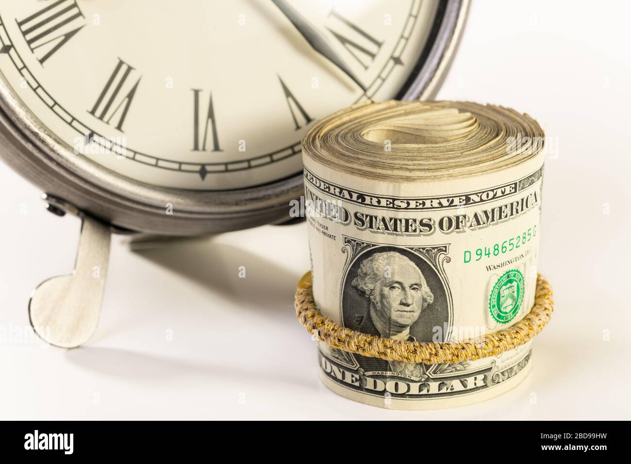 Denaro americano seduto vicino al desktop orologio. Il tempo è denaro o concetto di pianificazione finanziaria. Foto Stock