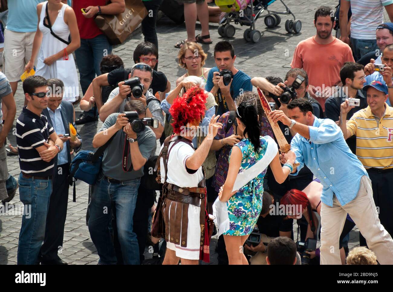 Un americano pone una regina di bellezza turisti (erroneamente) presumono sia famoso con un artista di costume durante le riprese fotografiche, Piazza di Spagna, Roma, Italia, colore Foto Stock