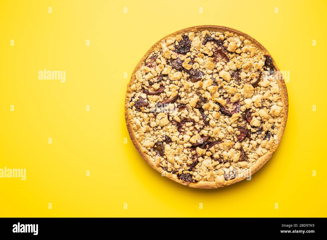 Torta di prugna dolce su sfondo giallo. Vista dall'alto. Foto Stock
