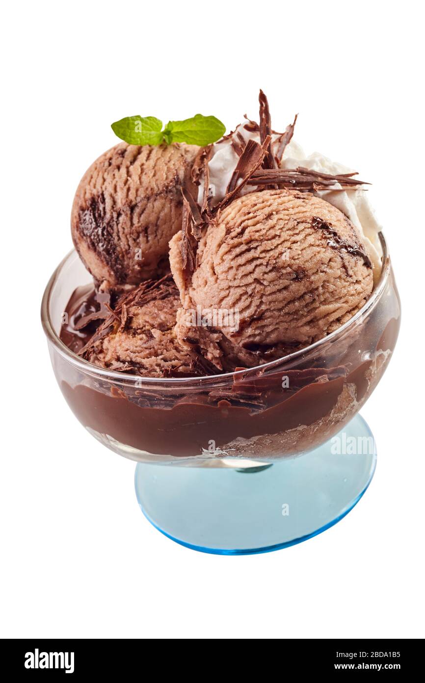 Scoop di gelato al cioccolato guarnito con fiocchi e foglie di menta fresca in un piatto di vetro a piedistallo isolato su bianco Foto Stock