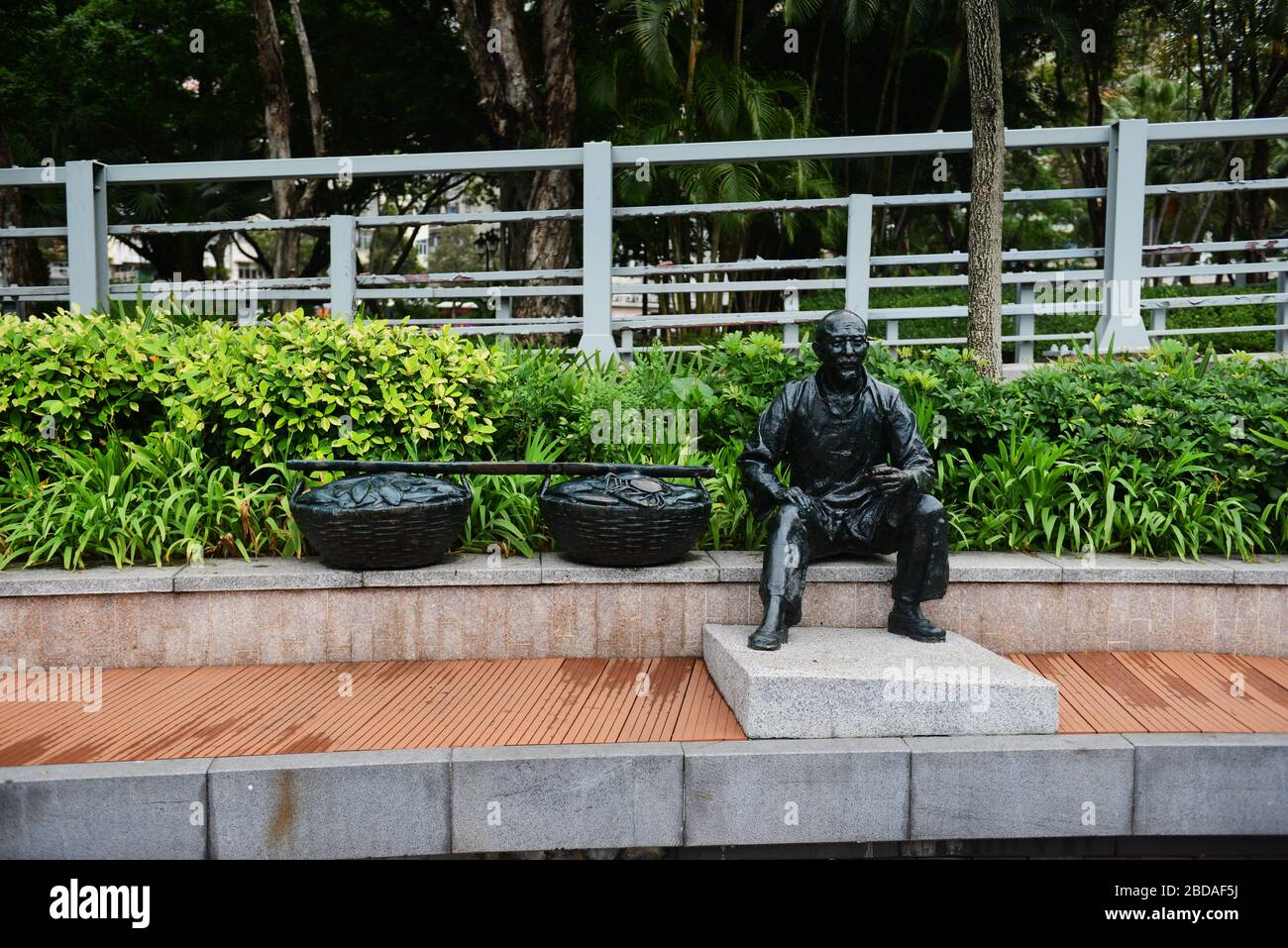 Una statua di un vecchio pescatore con la sua cattura in cesti sulla passeggiata di Aberdeen a Hong Kong. Foto Stock
