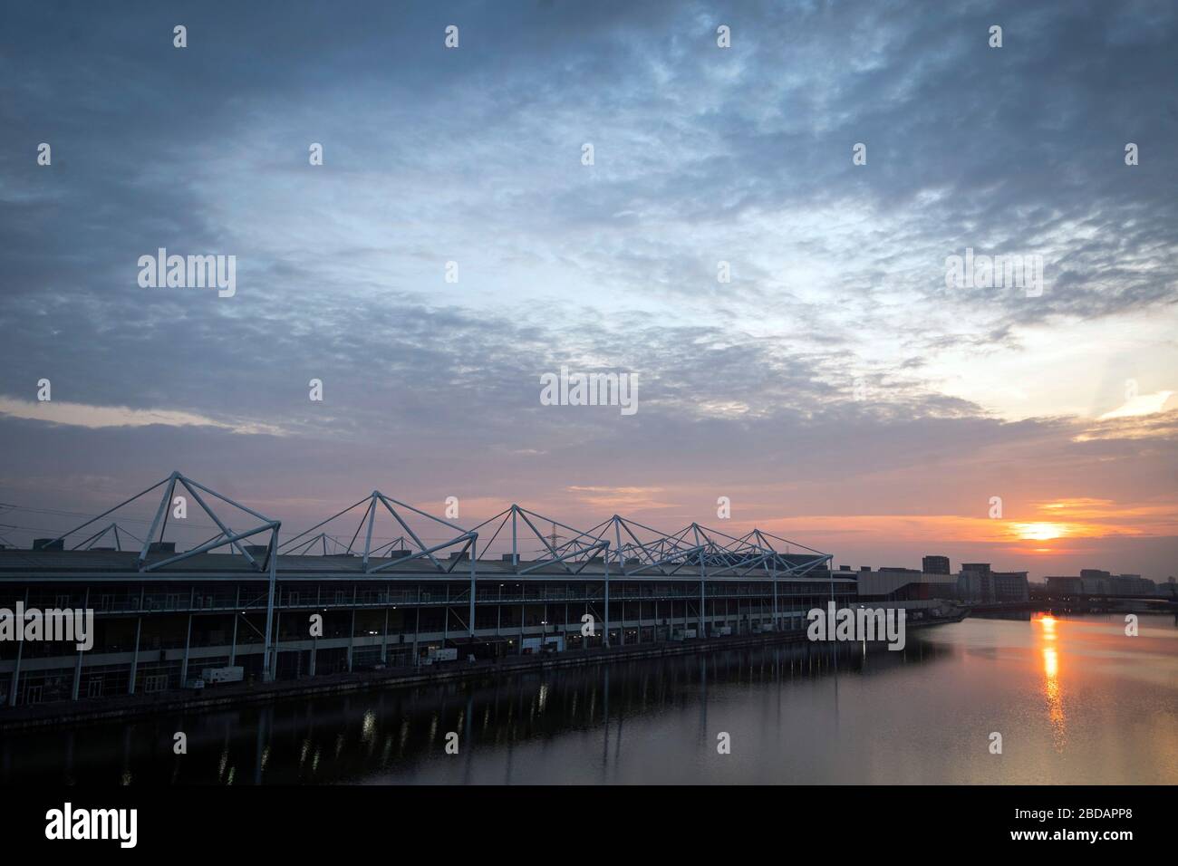 Il sole sorge dietro il NHS Nightingale Hospital presso il centro Excel di Londra, un ospedale temporaneo con 4000 posti letto, in quanto inizia ad ammettere i pazienti di Covid-19, mentre il Regno Unito continua a bloccarsi per contribuire a frenare la diffusione del coronavirus. Foto Stock