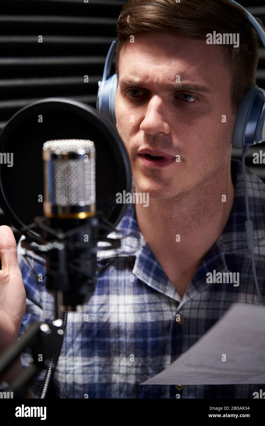 Artista VoiceOver maschile in Recording Studio che parla con il microfono Foto Stock
