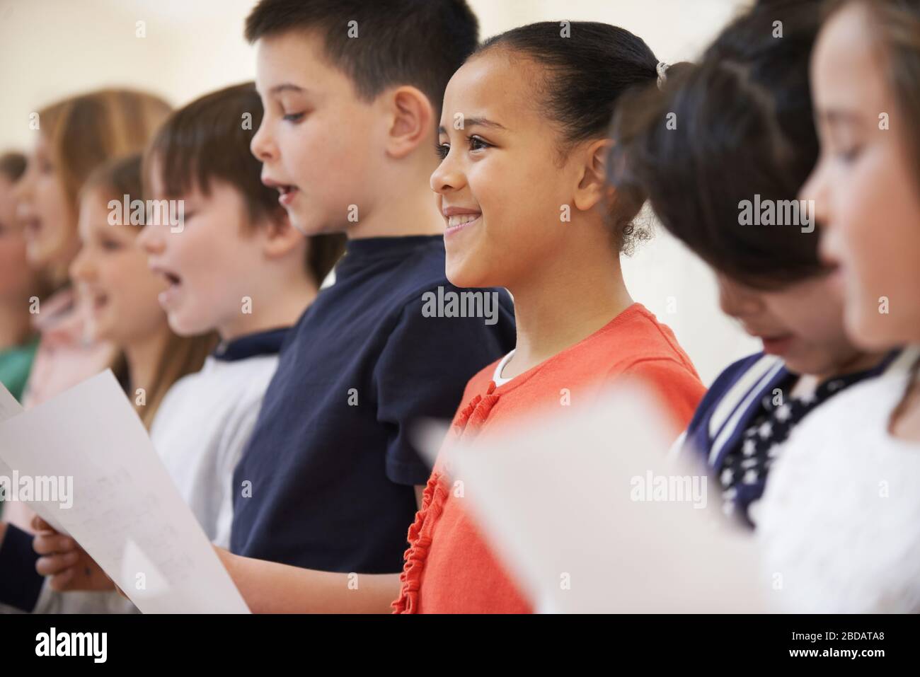 Gruppo di bambini della scuola cantando in coro alla Scuola di Stage insieme Foto Stock