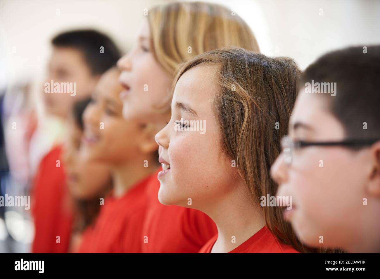 Gruppo di bambini della scuola cantando in coro alla Scuola di Stage insieme Foto Stock