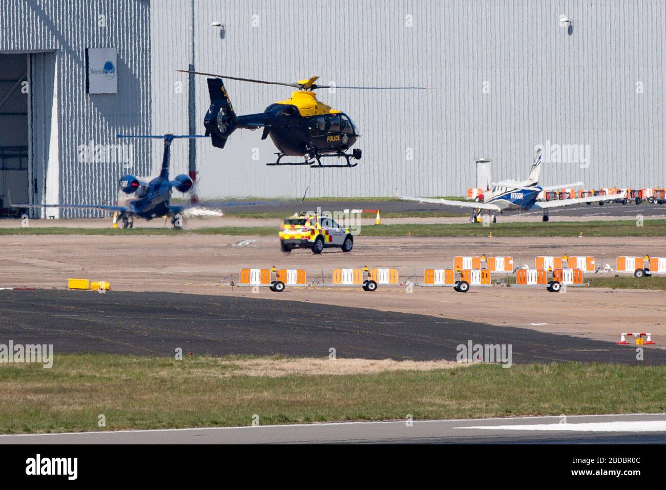 Un elicottero della polizia decollo dal mortuario temporaneo all'aeroporto di Birmingham che, secondo quanto riferito, è destinato a diventare operativo nei prossimi giorni, mentre il Regno Unito continua a bloccarsi per contribuire a frenare la diffusione del coronavirus. Foto Stock