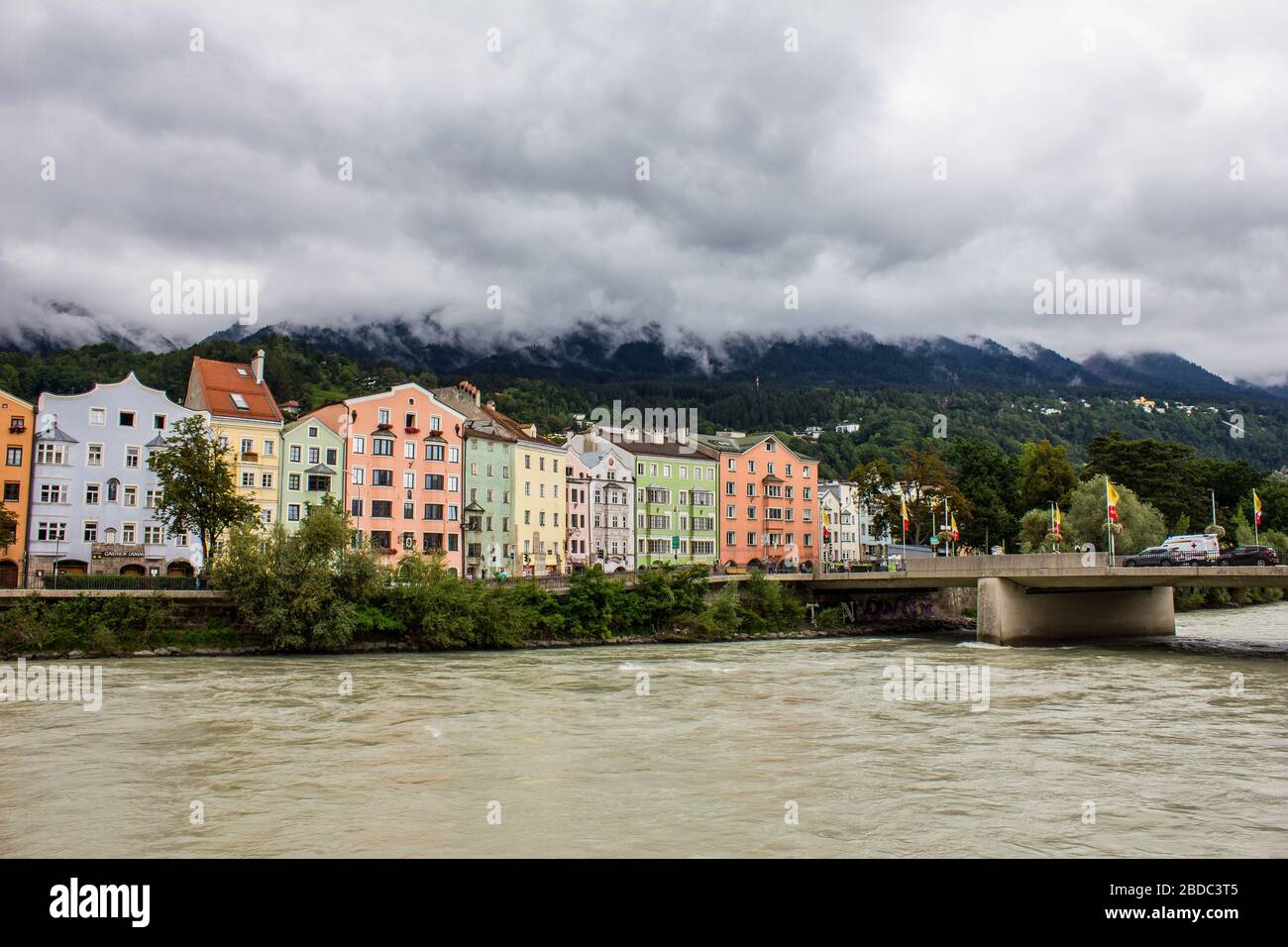 Innsbruck, Austria - 12 agosto 2019: Edifici colorati sulla riva del fiume Inn con le montagne Nordkette sullo sfondo. Foto Stock