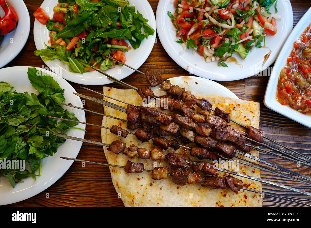 Il tavolo è servito anche con antipasti turchi e varietà di insalate. Un tipo di kebab spesso fatto nelle province meridionali della Turchia. Fuori Foto Stock