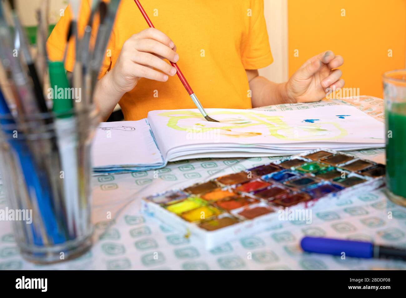disegno di materiali su sfondo sfocato e ragazzo è pittura. attività creative e tempo libero per i bambini a casa. Foto Stock
