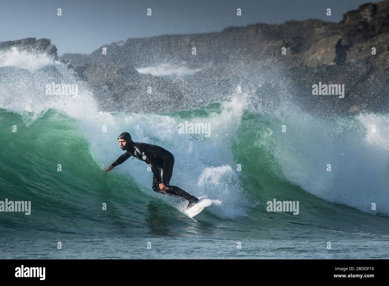 Un surfista a cavallo di un onda al Fistral a Newquay in Cornovaglia. Foto Stock