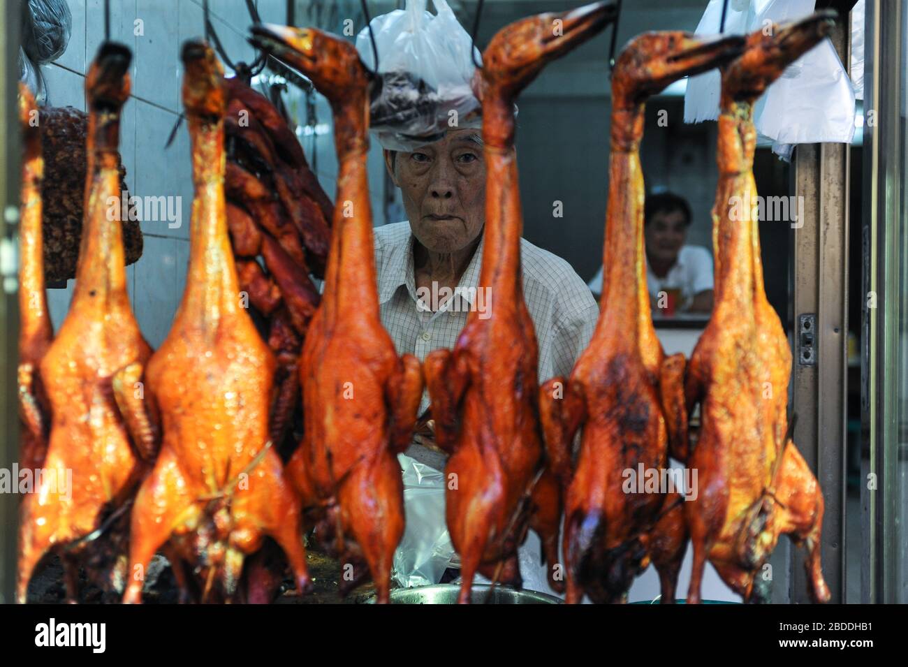 09.01.2014, Yangon, , Myanmar - un uomo sta in piedi in un ristorante dietro le anatre arrostite appese dai ganci. 0SL140109D001CAROEX.JPG [VERSIONE MODELLO: NO, Foto Stock