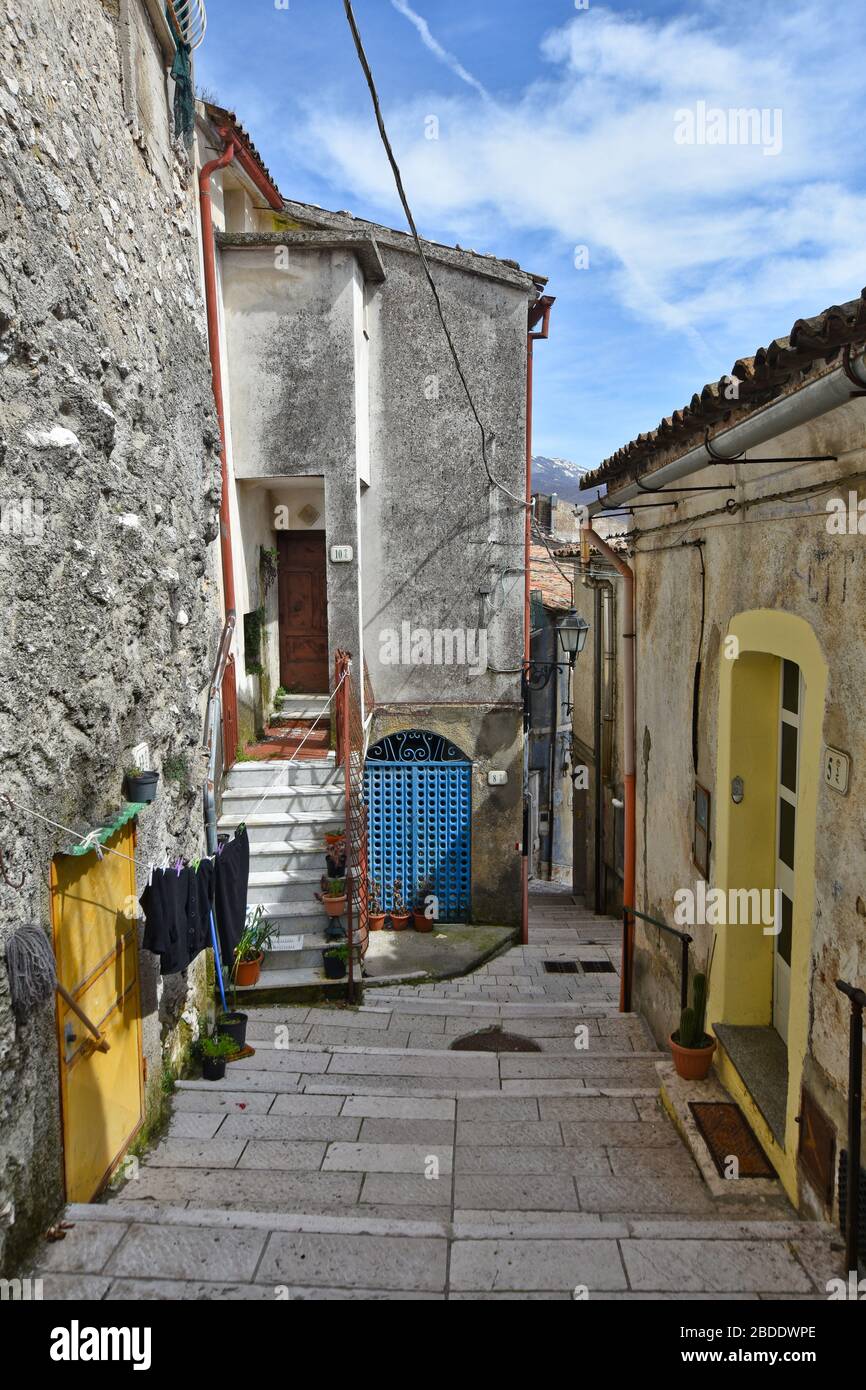 Una strada stretta tra le vecchie case di un villaggio nel sud Italia Foto Stock