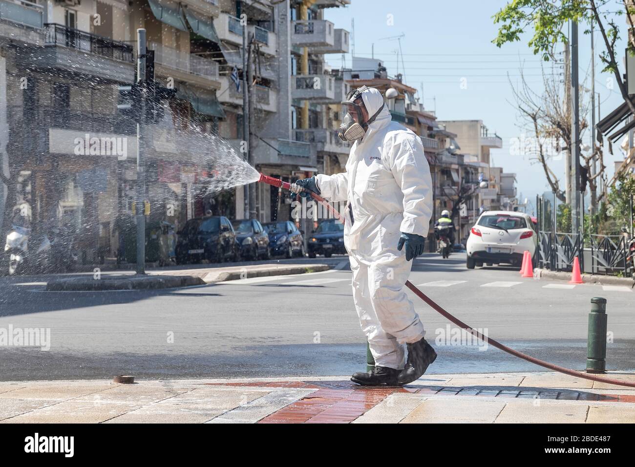 Salonicco, Grecia - 8 aprile 2020: I lavoratori spruzzano disinfettante nell'ambito di misure preventive contro la diffusione del COVID-19, il romanzo coronav Foto Stock