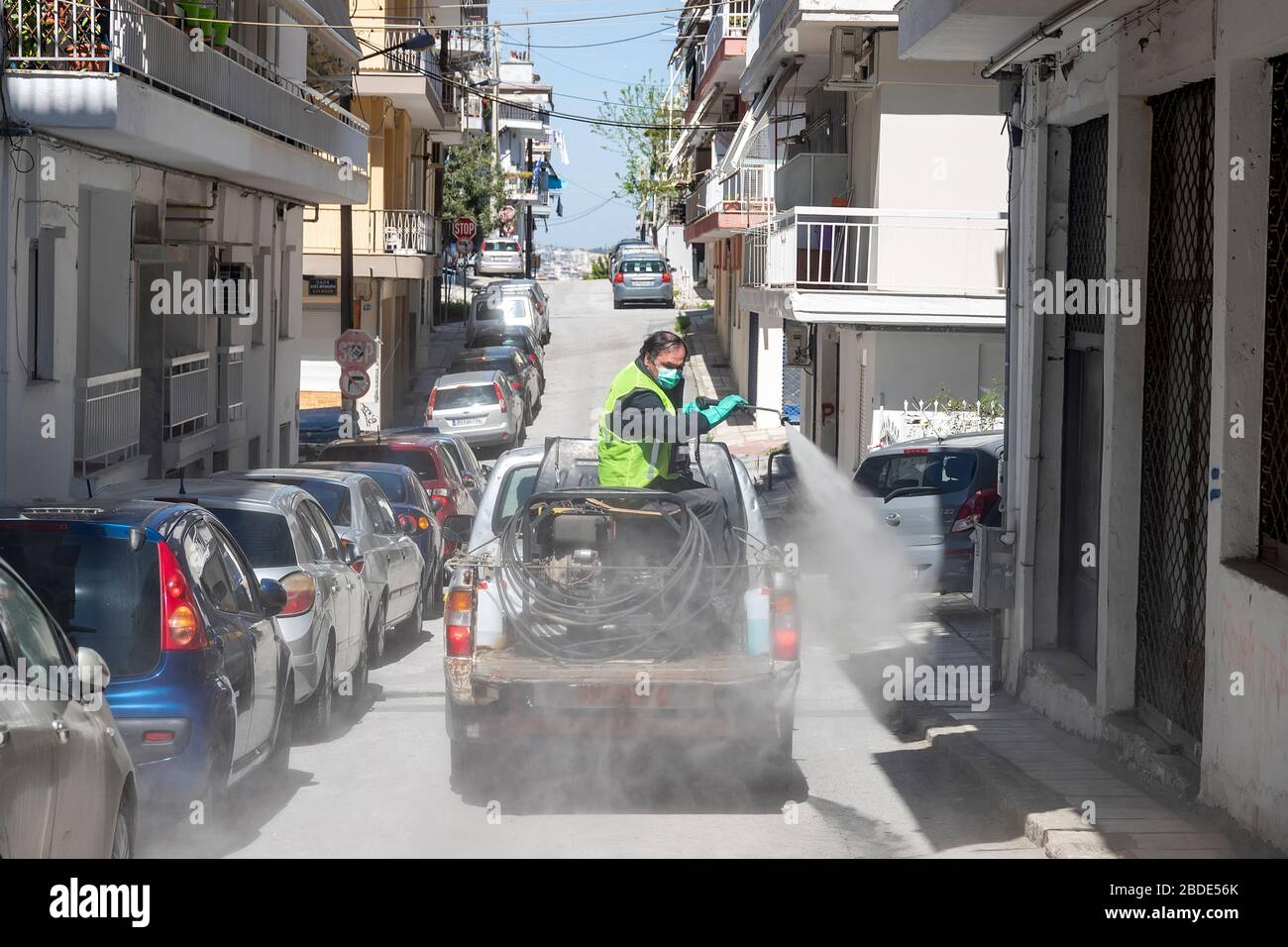 Salonicco, Grecia - 8 aprile 2020: I lavoratori spruzzano disinfettante nell'ambito di misure preventive contro la diffusione del COVID-19, il romanzo coronav Foto Stock