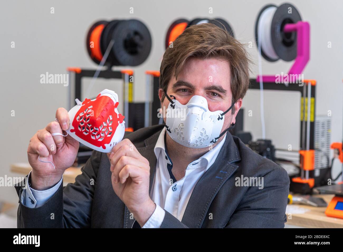 07 aprile 2020, Baviera, Ratisbona: Harald Schmid mostra una maschera protettiva da una stampante 3D. Le maschere sono stampate in plastica flessibile. L'acquirente può assemblare la maschera protettiva direttamente dalla maschera stampata, dagli elementi di collegamento, dai filtri e dalle fasce in gomma. Foto: Armin Weigel/dpa Foto Stock