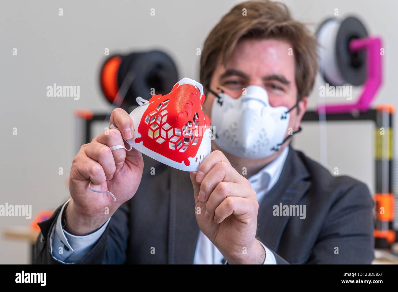 07 aprile 2020, Baviera, Ratisbona: Harald Schmid mostra una maschera protettiva da una stampante 3D. Le maschere sono stampate in plastica flessibile. L'acquirente può assemblare la maschera protettiva direttamente dalla maschera stampata, dagli elementi di collegamento, dai filtri e dalle fasce in gomma. Foto: Armin Weigel/dpa Foto Stock