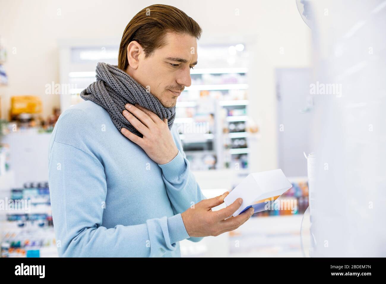 Uomo bello focalizzato che ha mal di gola e sensazione di male Foto Stock