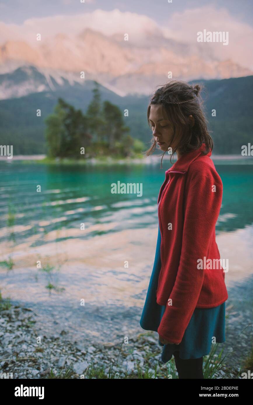 Germania, Baviera, Eibsee, giovane donna in piedi sulla riva del lago ofÂ EibseeÂ nelle Alpi Bavaresi Foto Stock