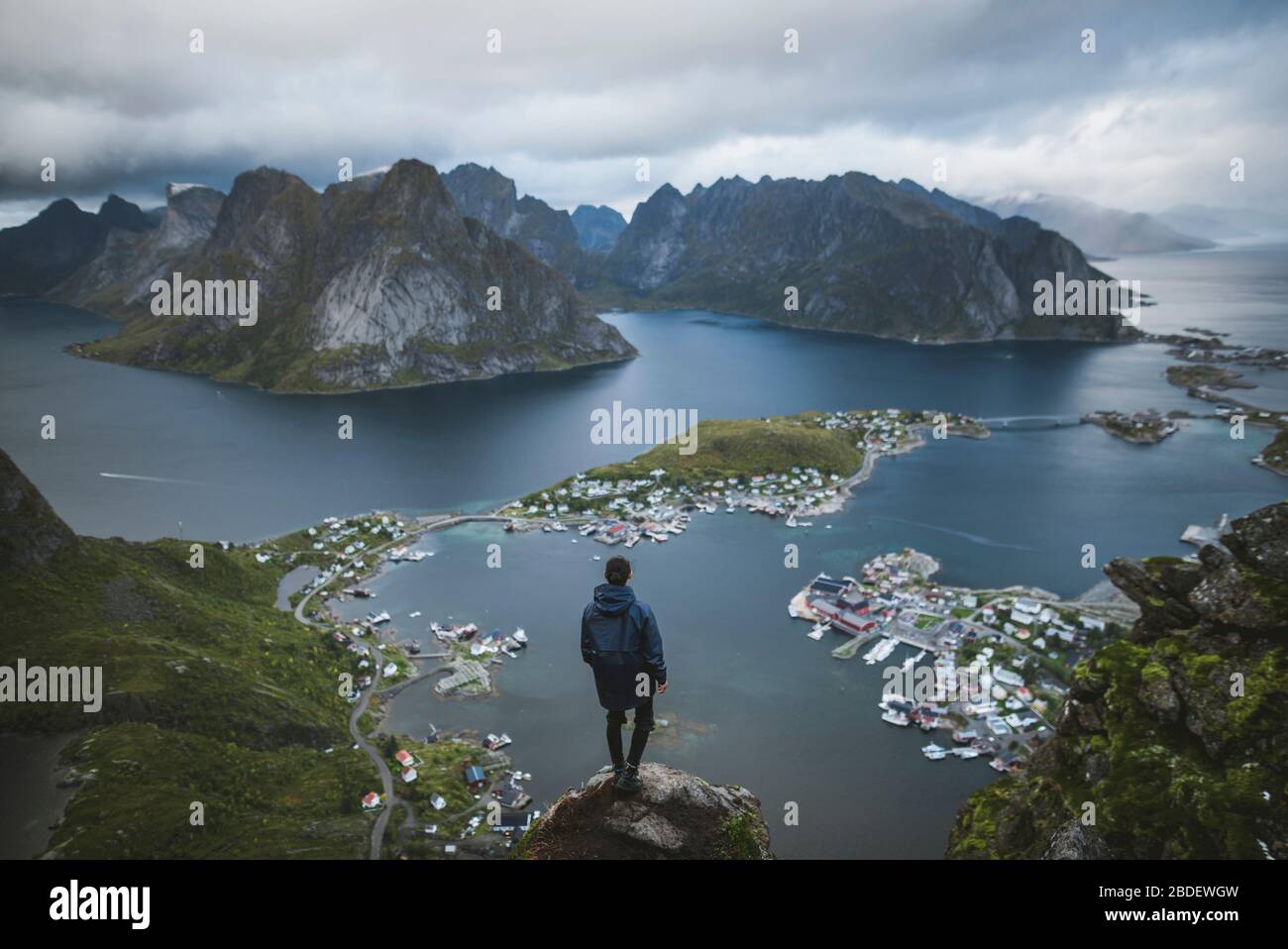 Norvegia, Isole Lofoten, Reine, uomo guardando il fiordo fromÂ ReinebringenÂ montagna Foto Stock