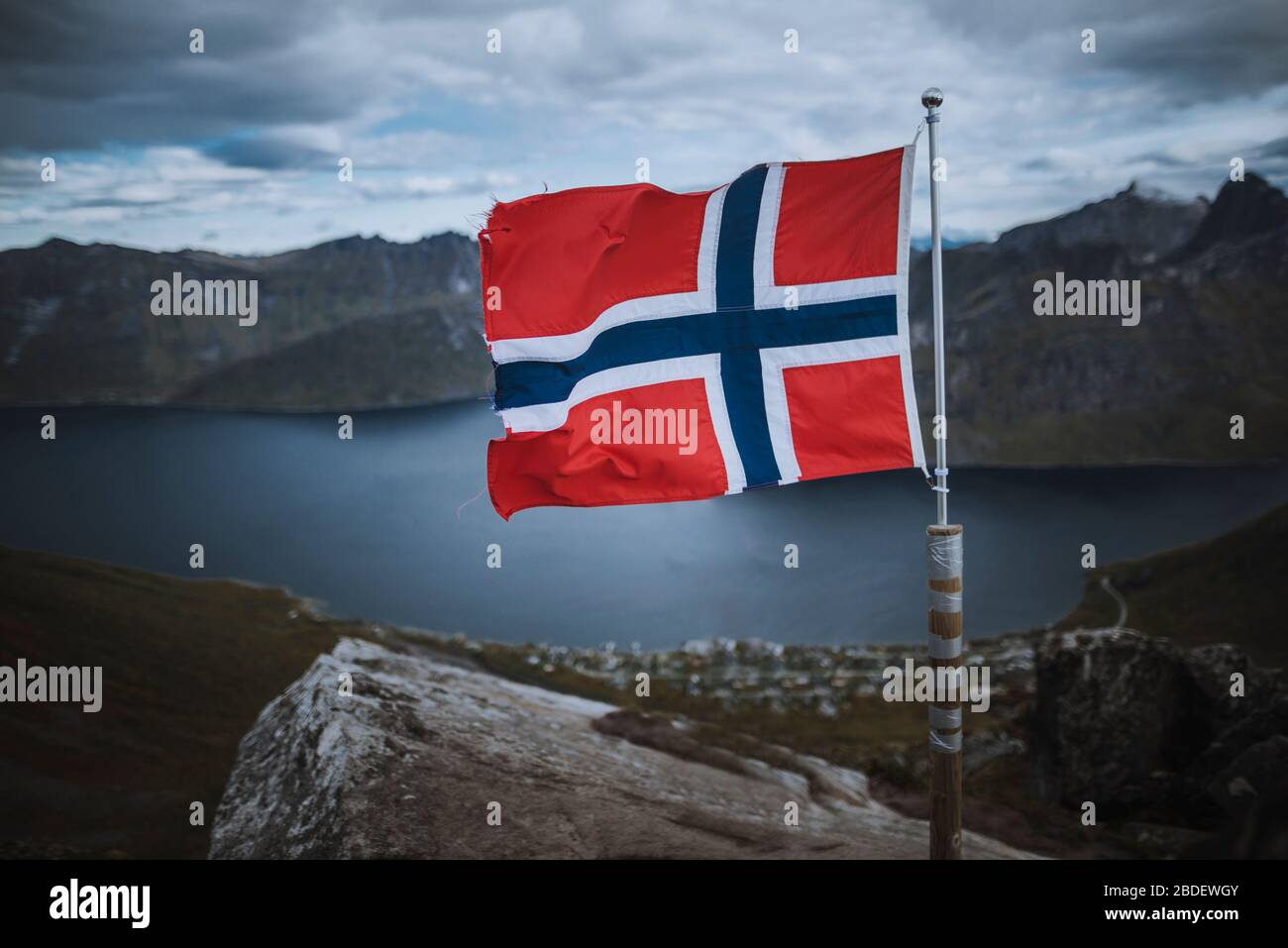 Norvegia, Senja, bandiera norvegese con fiordo e montagne sullo sfondo Foto Stock